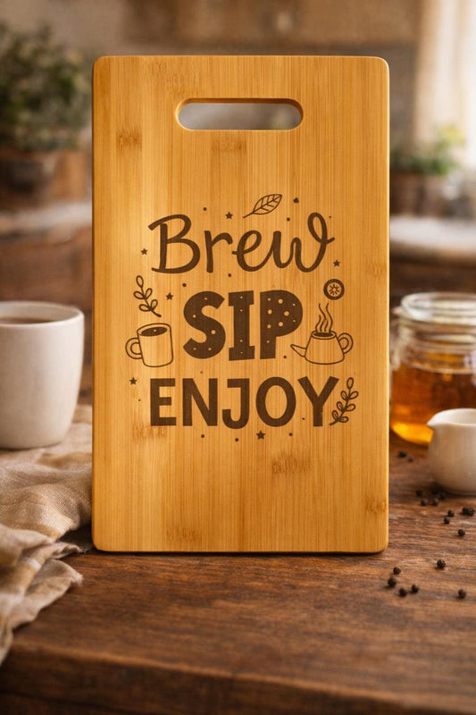 Wooden cutting board with 'Brew Sip Enjoy' engraving on a kitchen counter.