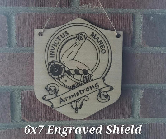 Engraved shield with a design and text, hanging on a brick wall.